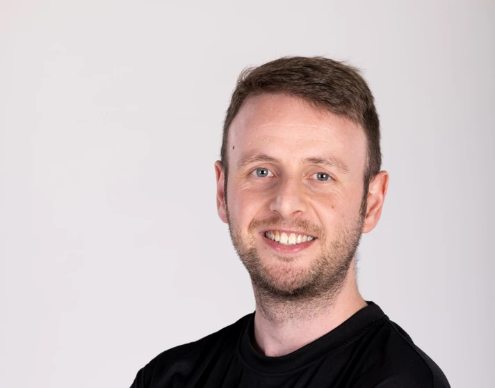 Grant Sutherland smiling with arms crossed, wearing a Glasgow Kelvin College branded sports t-shirt against a plain background. Grant Sutherland smiling with arms crossed, wearing a Glasgow Kelvin College branded sports t-shirt against a plain background.